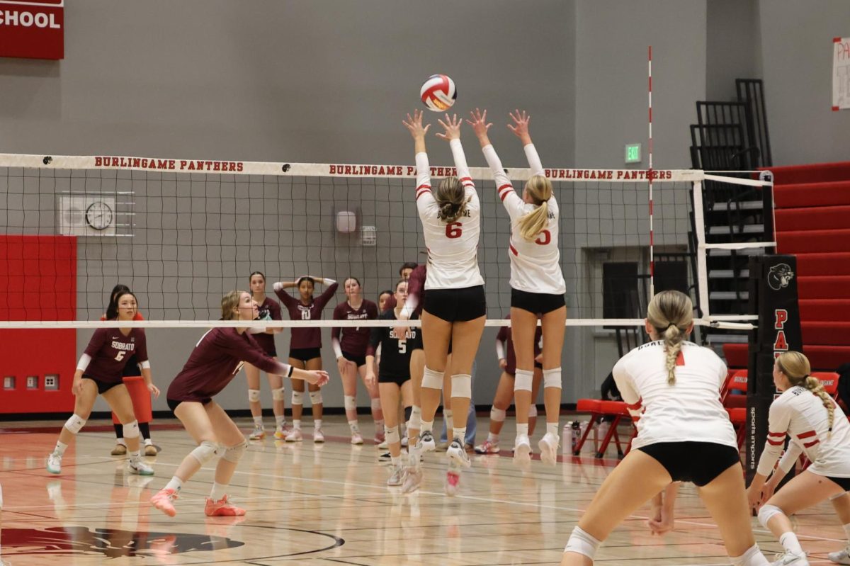 Junior outside hitter Julia Ott and senior middle blocker Ava Scatena jump to push the ball over the net, securing their lead.