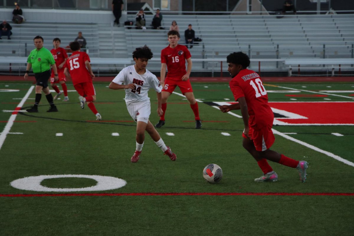 Junior midfielder Ayaan Palaniappan dribbles the ball up and prepares to make a pass.