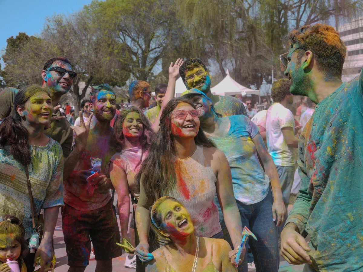 Gulal-covered attendees gather for a selfie during the festival. One important aspect of Holi is celebrating with family and friends as they welcome the spring season.
