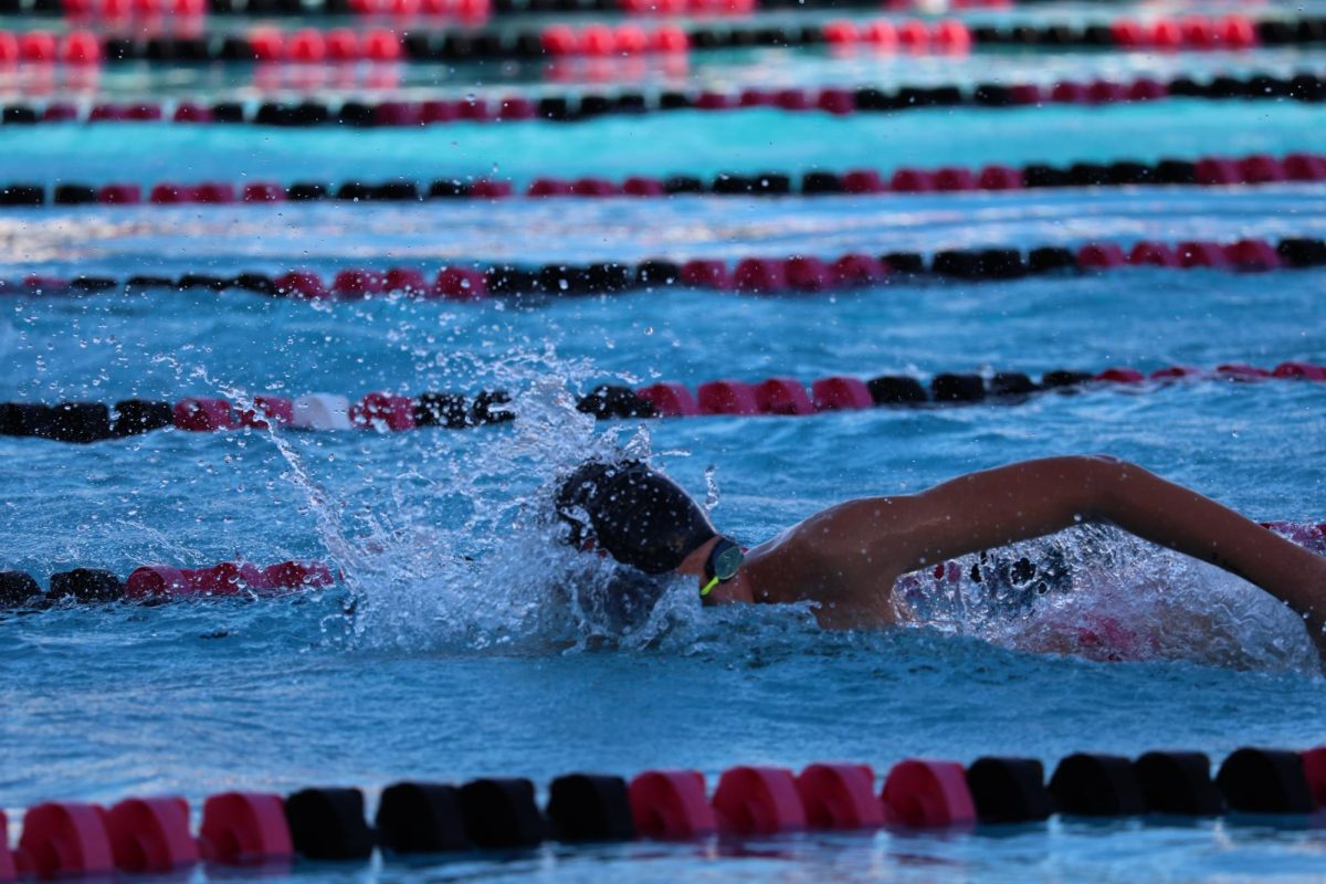 Junior varsity freshman Henry Hopkins swims freestyle in his relay. 
