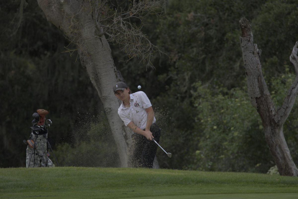 Senior Ethan Cyb chips his way out of the sand pit.