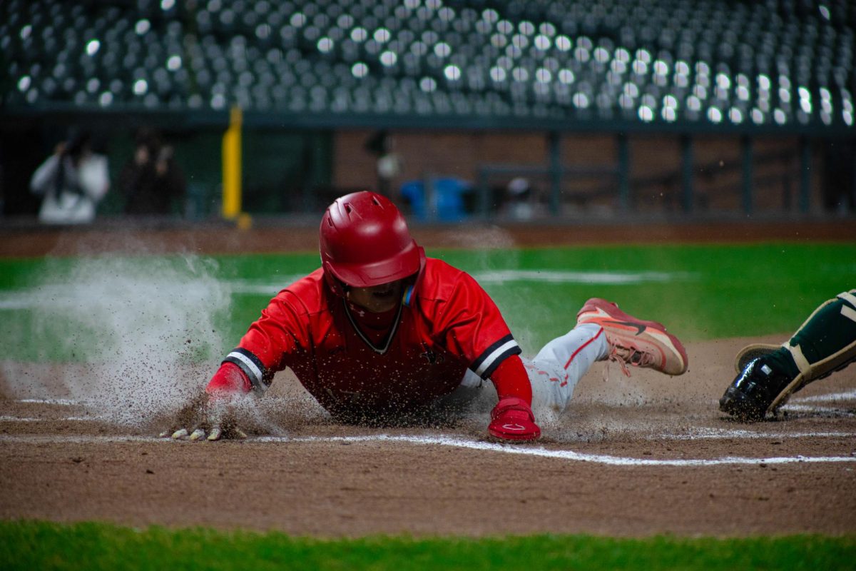 Junior second baseman Charlie Cheng dives into home, scoring the tying run.