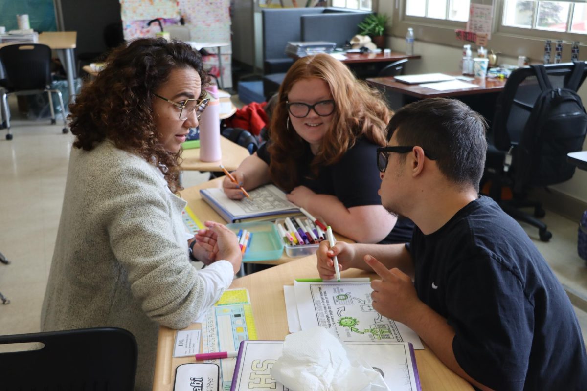 Junior Jamieson Trefz and freshman Angelo Vega-Delgadillo draw on a worksheet displaying scientific ideas.