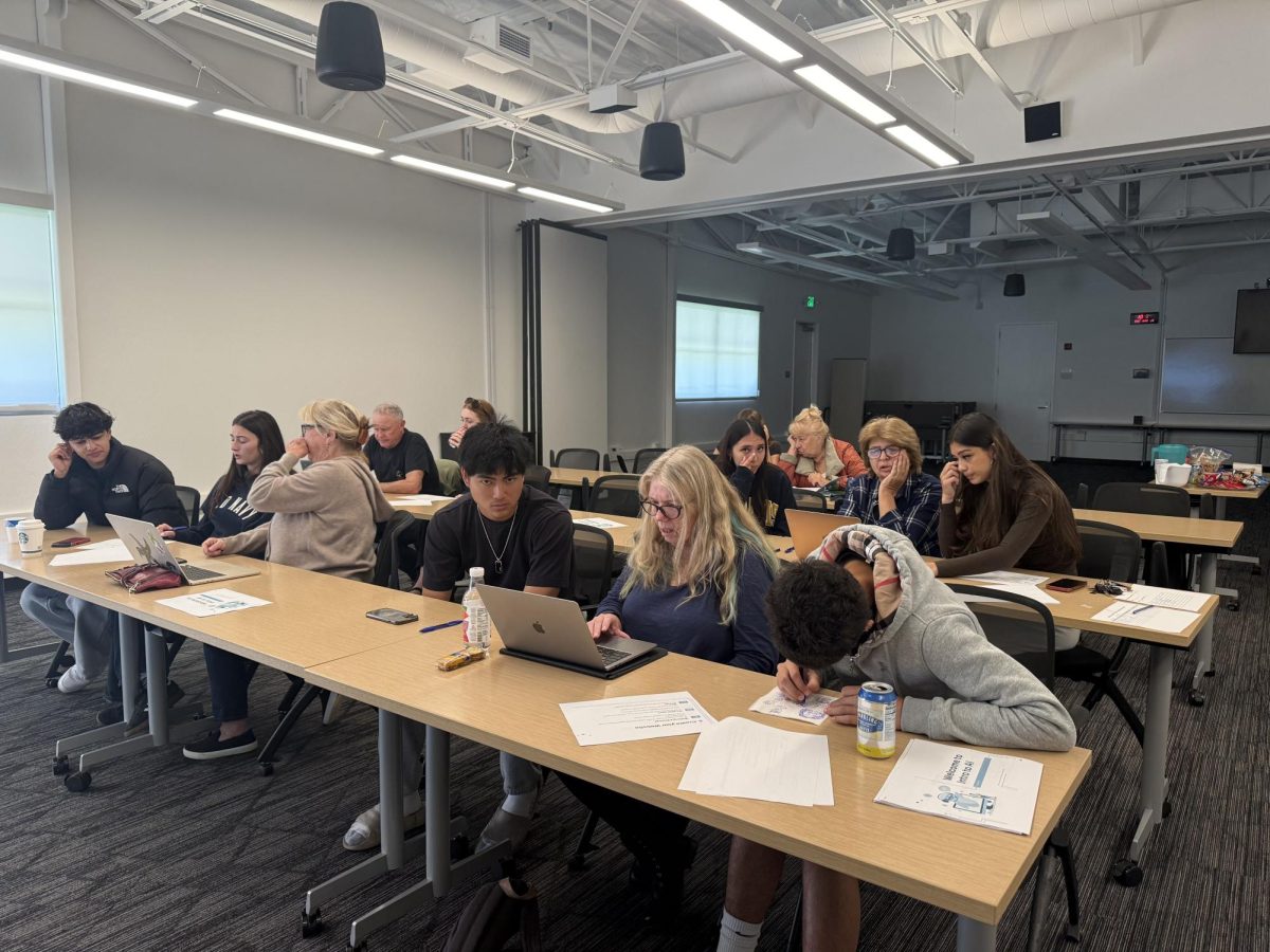 Volunteers help senior citizens improve their media literacy during a session.