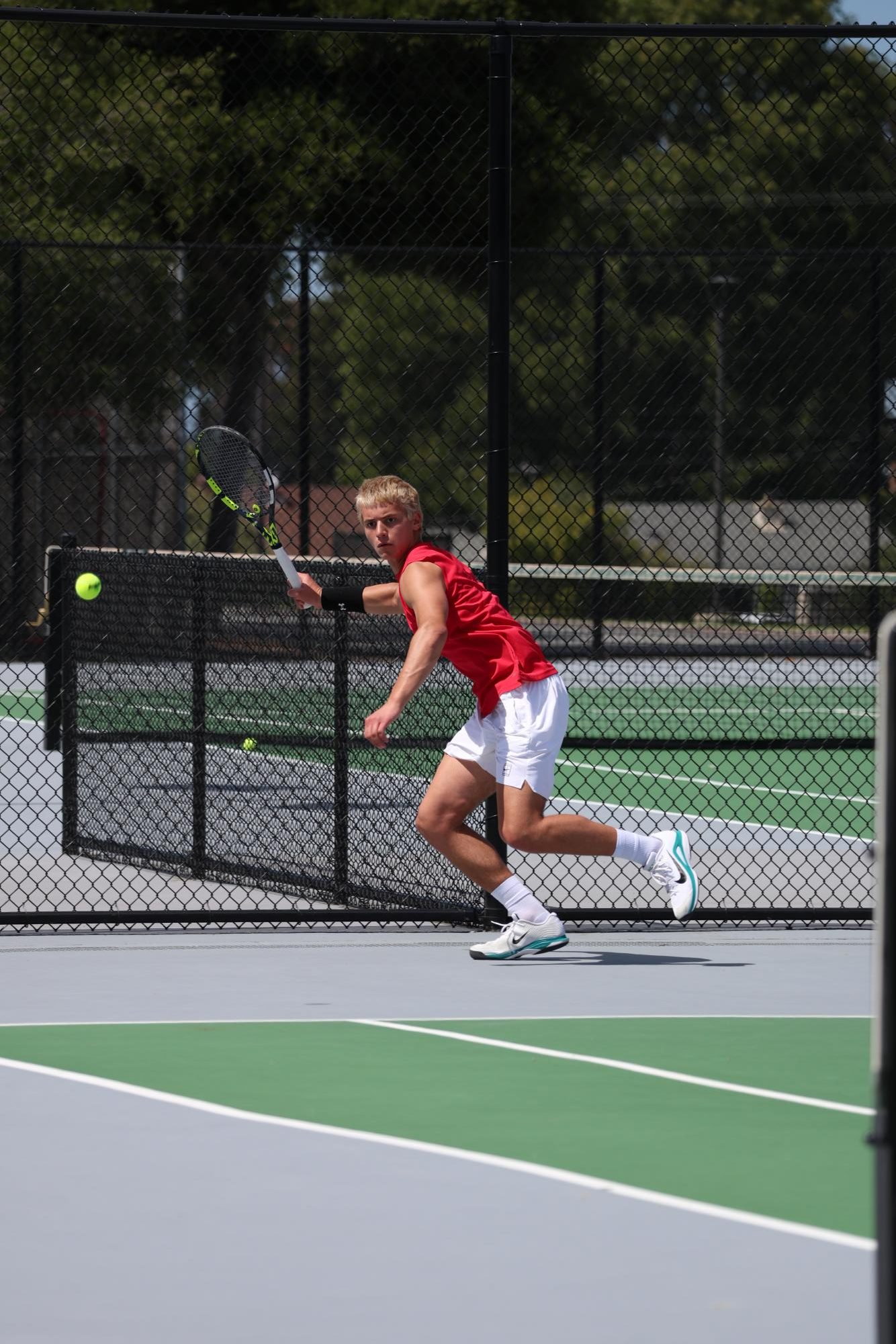 Senior Alex Bonzinovic runs to return the ball to his opponent.