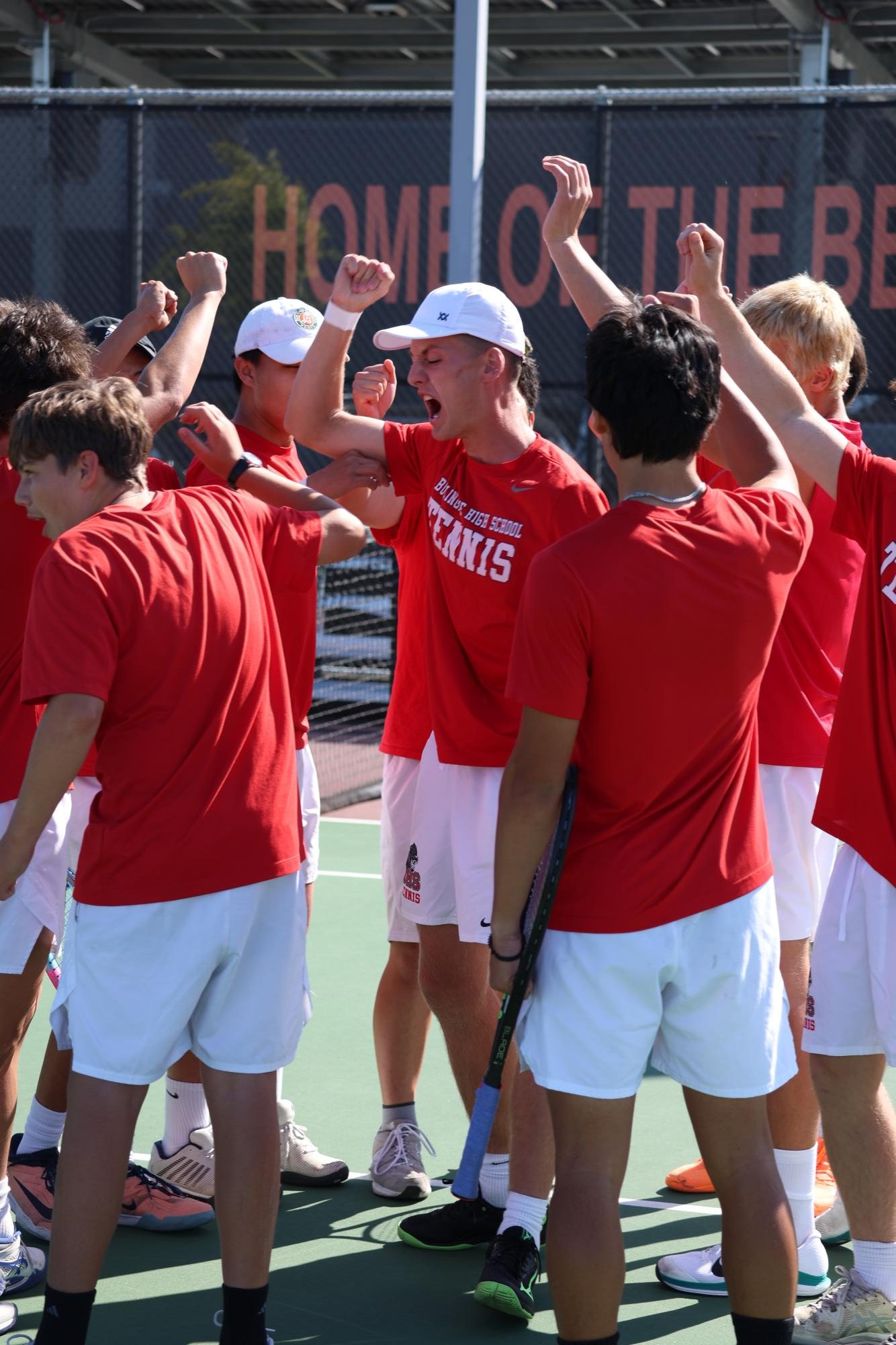 The boys’ tennis team huddles together as No. 1 doubles player and captain senior Jake Druskin leads the team in a cheer before their first-round CCS Team Tournament match against Leigh High School.