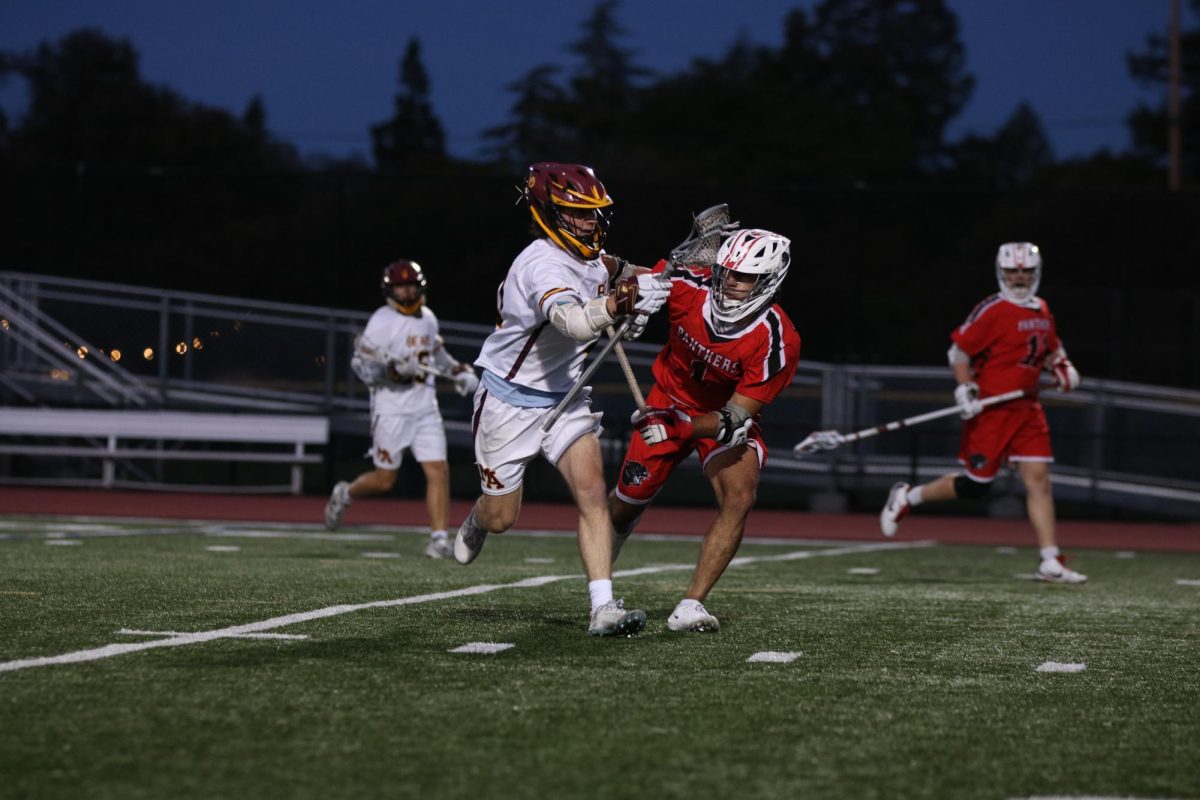 Senior attackman Ravi Krishnan plays heavy defense against the Bears during the third quarter. While Menlo-Atherton High School is four points up at this point, Burlingame holds that margin for the remainder of the game.